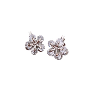Boucles d'oreilles fleur en argent avec zircons à cinq pétales sur un fond blanc pur