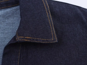 Vista dettagliata della trama del denim e delle cuciture di una giacca blu