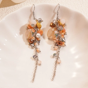 Detail of bohemian long tassel earrings with glass beads and metal leaf charms