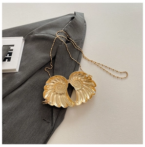 Detailsicht der goldenen schneckenförmigen Clutch mit Radialtextur und Magnetverschluss