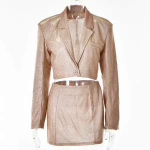 Détail de l'ensemble blazer doré à paillettes et mini-jupe sur un mannequin pro