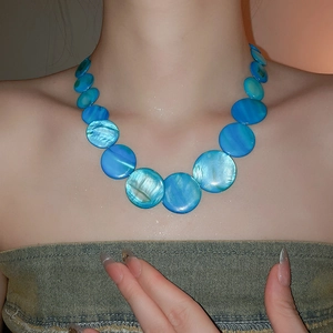 Close-up of blue shell bead necklace showing large to small gradient circular disks