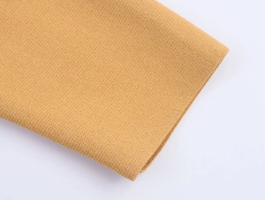 Close-up of ginger yellow knit cardigan showing ribbed cuffs and fine needlework texture