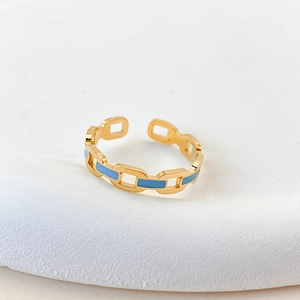 Detailed macro view of the gold chain link ring with light blue enamel inlay and open band