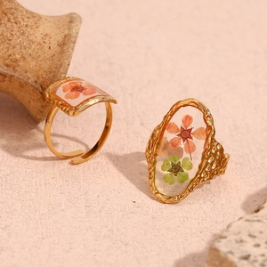 Detail of 18K gold-plated hammered texture rings with dried flowers in resin