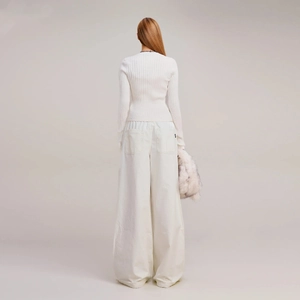 Rear view of model wearing a white slim-fit ribbed cardigan and wide-leg trousers