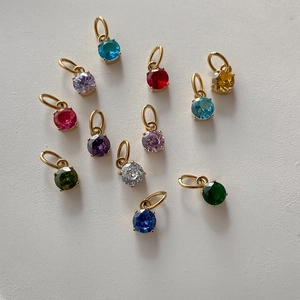 Assorted colorful round gemstone pendants in gold-plated stainless steel settings.