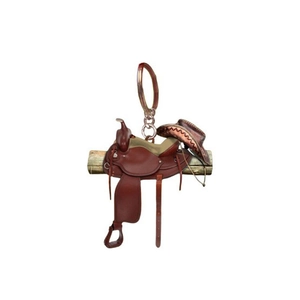Détail du pendentif selle et chapeau de cowboy suspendu sur un support en bois