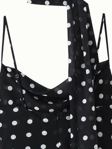 Detailed view of adjustable spaghetti straps on a polka dot dress with metal buckles