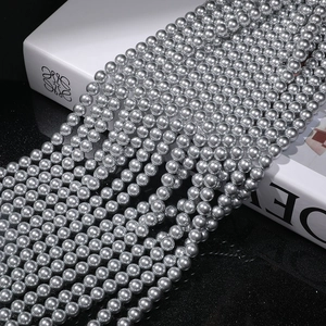 Macro shot of silver-grey round pearls with high metallic luster arranged in rows