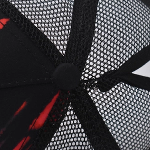 Detailed macro view of black mesh truck hat crown with vibrant red flame print pattern