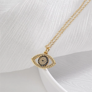 Detailed view of evil eye necklace with gold chain and sparkling blue crystals