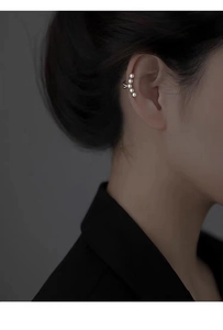 Close-up of elegant silver-plated ear cuff with five pearls in a curved row