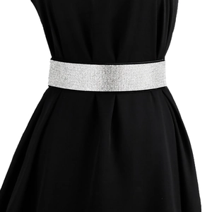 Close-up of sparkling silver rhinestone elastic wide belt on a black dress