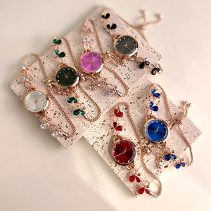 Macro view of six bracelet watches with butterfly crystals on light beige stone plates