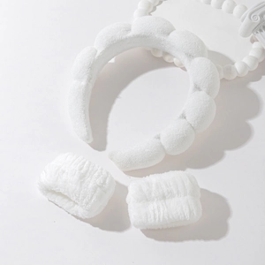 Detailed view of white fluffy spa headband and matching wristbands for face washing