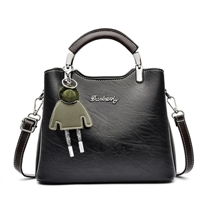Classic black leather handbag with top handle and detachable strap on white background