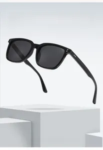 Detail view showing metal rivet studs on the black square frame of fashion sunglasses