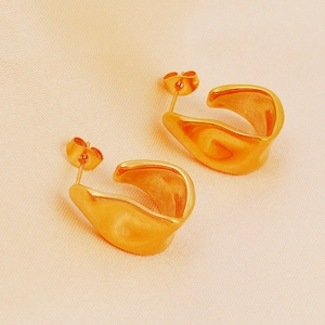 Minimalist irregular U-shaped 18K gold plated stainless steel earrings on beige fabric