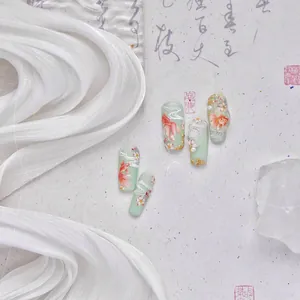 Detail of mint green nail stickers featuring red koi fish and white cherry blossoms