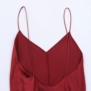 Dettaglio abito sottoveste in raso rosso scuro con scollo a V profondo e spalline sottili