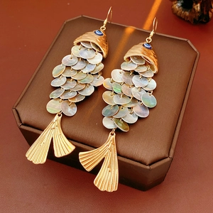 Detail of vintage fish earrings with gold accents and iridescent shell scales