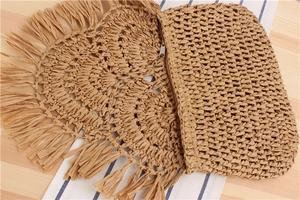 Detail of handmade crochet woven clutch with long fringes and metal zipper closure