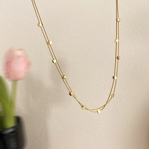 Elegante goldene zweischichtige Schlangenkette mit kleinen quadratischen Anhängern