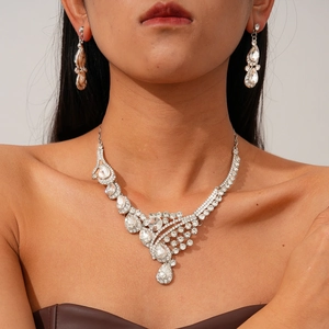 Detailed view of silver crystal necklace and waterdrop earrings on a model neck