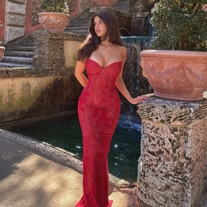 Detailopname van rode kanten fishtail-jurk met off-shoulder ontwerp en nauwsluitende pasvorm