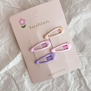 Pink and purple star-patterned teardrop snap hair clips set on pink card