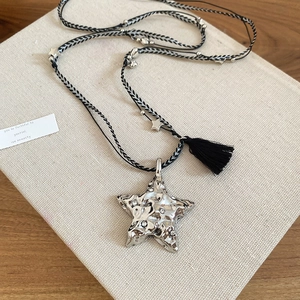 Détail du collier pendentif étoile avec cordon tressé et texture métallique élégante