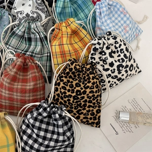 Flat lay of colorful drawstring bags in plaid, leopard, and floral patterns with cotton cords