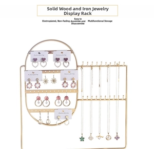 Detail of gold metal jewelry organizer with perforated board and necklace hooks