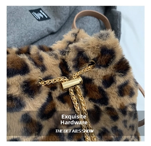 Detail of plush leopard print fabric with luxury gold chain and metallic buckle
