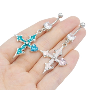 Détail de piercings de nombril croix avec gemmes en forme de cœur rose et turquoise