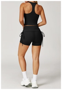 Detail of racerback sports bra and black drawstring yoga shorts with premium texture