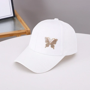 White baseball cap with rhinestone butterfly and jacquard texture on white surface