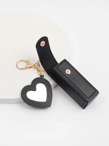 Detail view of black PU leather lipstick holder with heart mirror and gold keychain