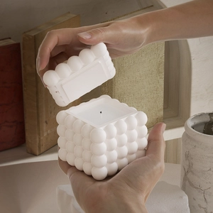 Bougie parfumée cube à bulles blanche avec couvercle dans un décor chaleureux