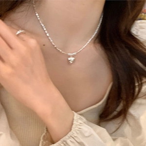 Elegant silver heart necklace with pearl accents shown on model for a minimalist style