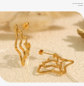 Detailed macro shot of golden minimalist irregular star earrings with polished finish