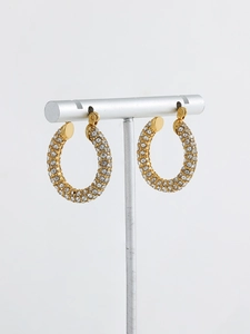 Close-up of 18K gold-plated twisted hoop earrings with pave-set shimmering crystals