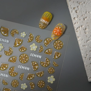 Detailed macro view of 3D embossed citrus nail stickers with lemon and orange slice designs