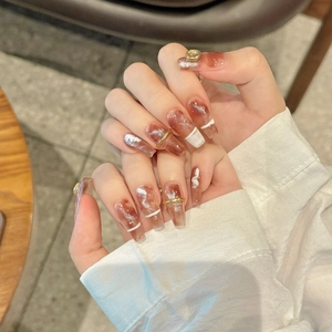 Handmade amber marble press-on nails with gold rings and pearls in coffin shape