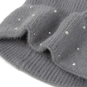 Detailed macro view of gray knitted fabric with plush texture and elegant pearl accents