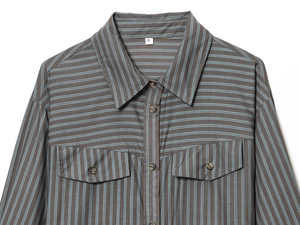 Détail de chemise en coton rayé gris montrant le col à revers et les poches poitrine