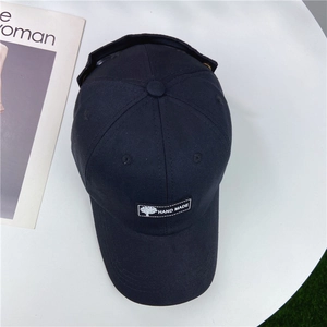 Detail of dark blue cotton pilot baseball cap with handmade label on white table