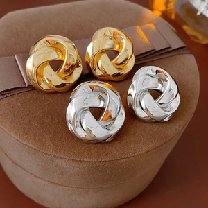 Gros plan de boucles d'oreilles torsadées dorées et argentées sur boîte velours