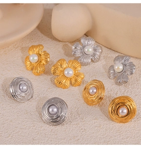 Detailed macro shot of vintage floral and spiral earrings with pearl inlay in gold and silver